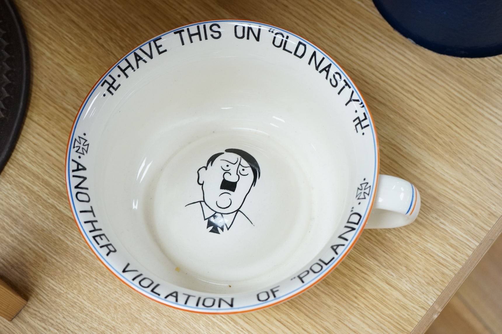 A WWII Fieldings Crown Devon novelty musical chamber pot, decorated with; No. 1 “Jerry”, Have This On Old Nasty, Another Violation of Poland and cartoon image of Adolf Hitler. Diameter 21.5cm, height 12cm